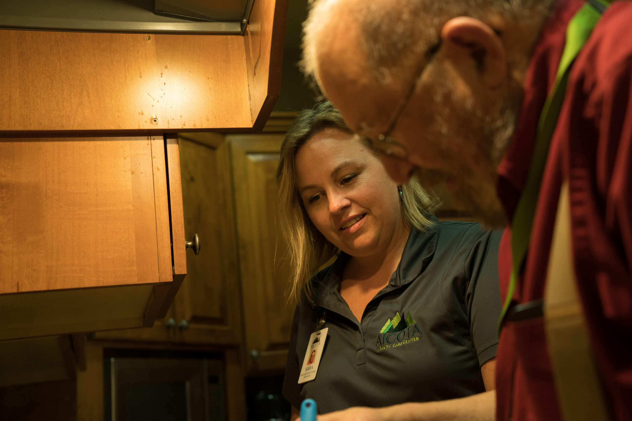 Nurse helping a resident in assisted living at Aicota Health Care Center