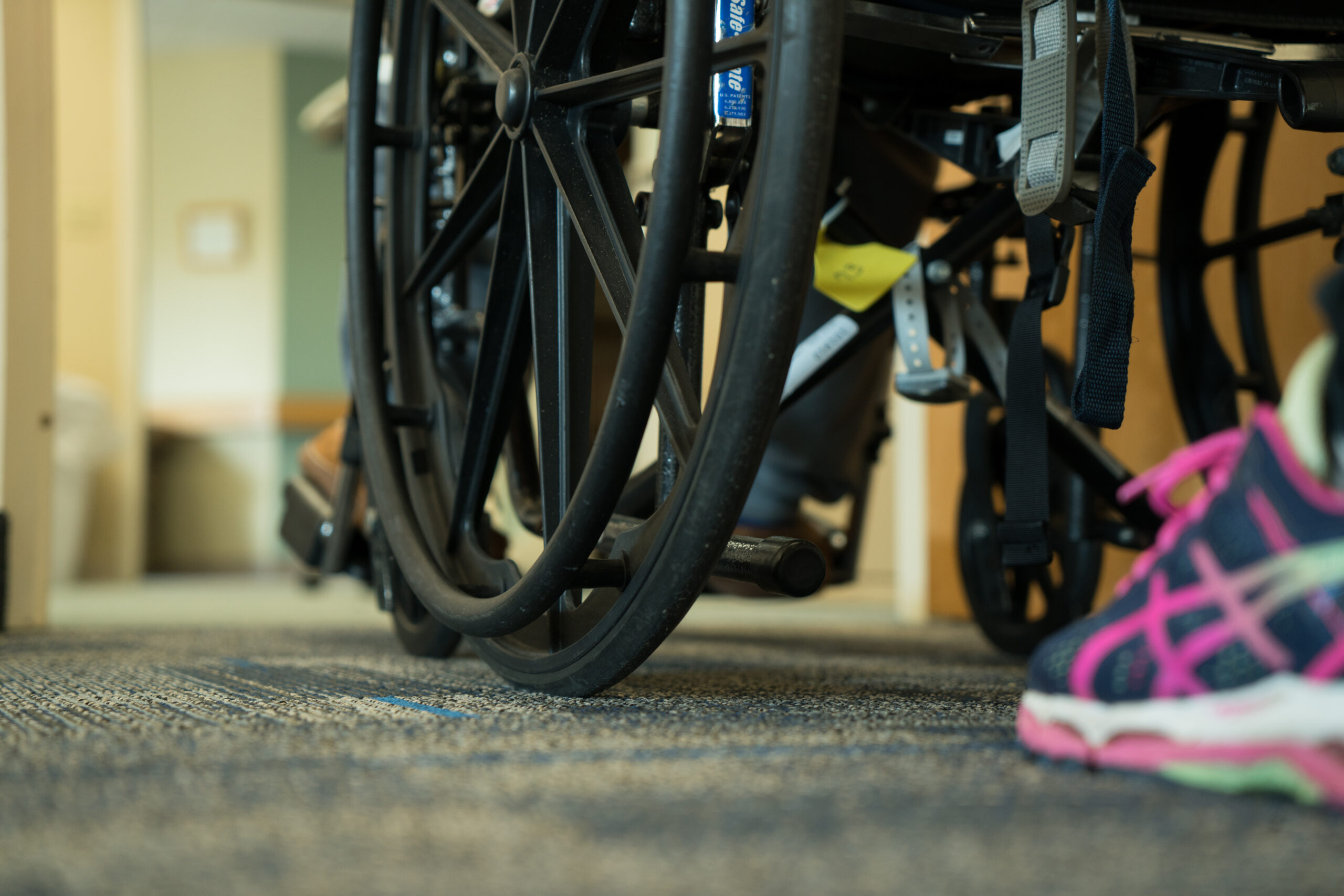 Nurse pushing someone in a wheel chair at Aicota Health Care Center